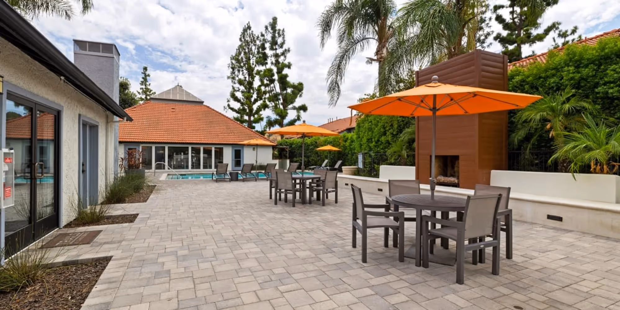 Pool deck with tables, chairs, and umbrellas
