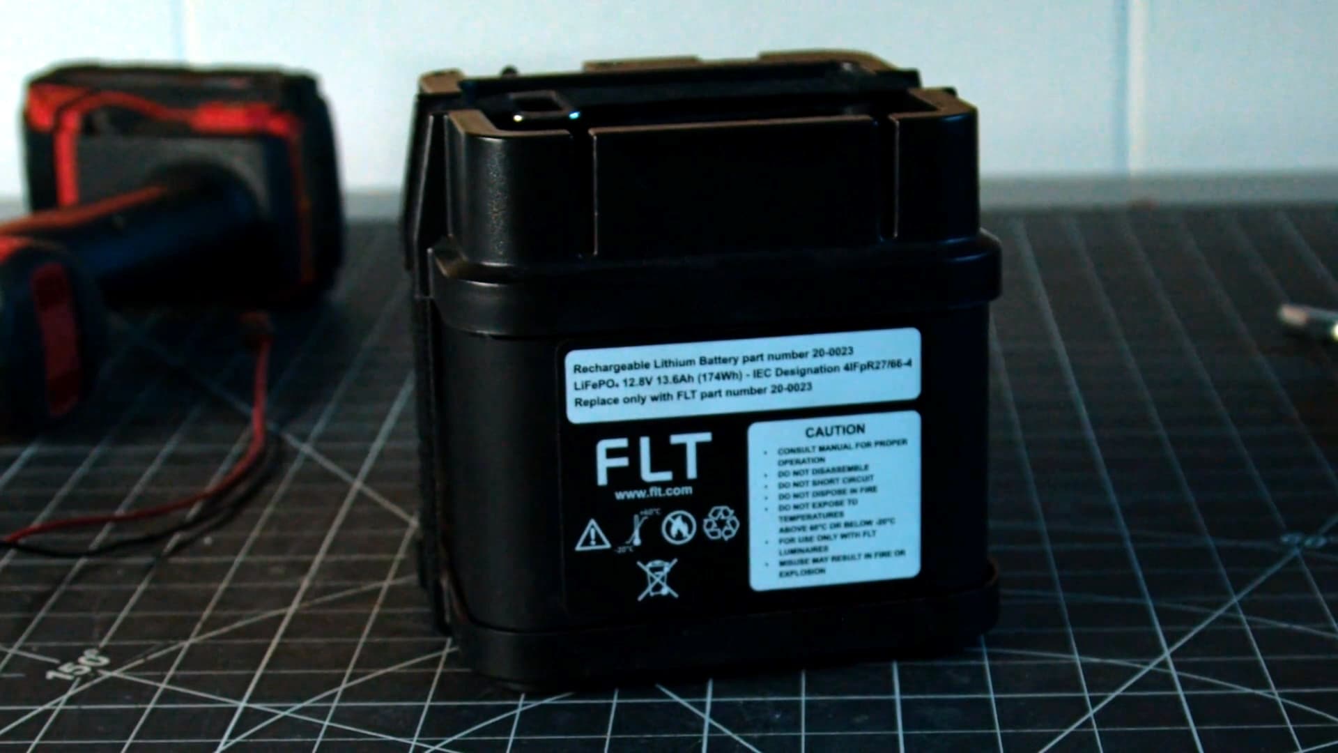 FLT LiFePO4 battery pack with product label showing specs and safety warnings