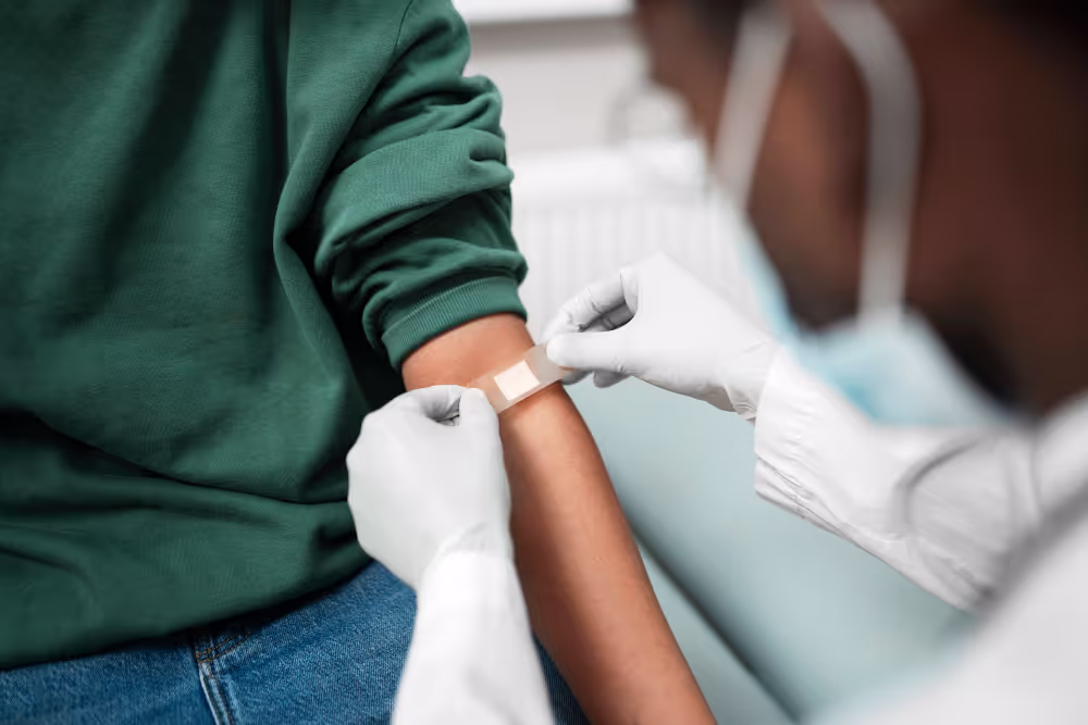 a patient getting a band aid placed on their arm after completing blood work.