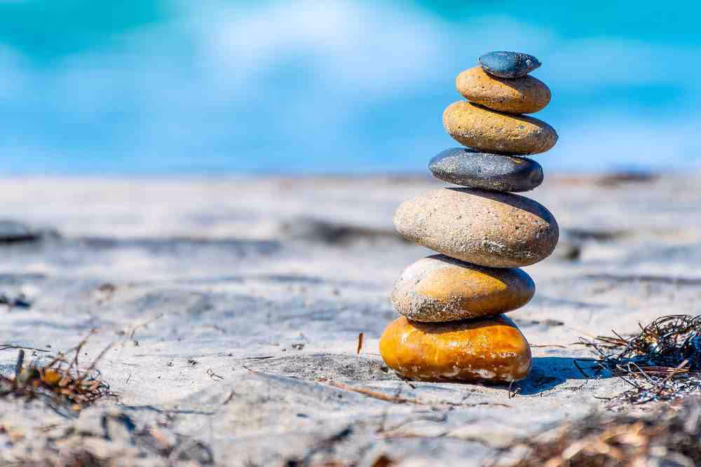 Scenic view of stacked stones naturally balanced on beach sand