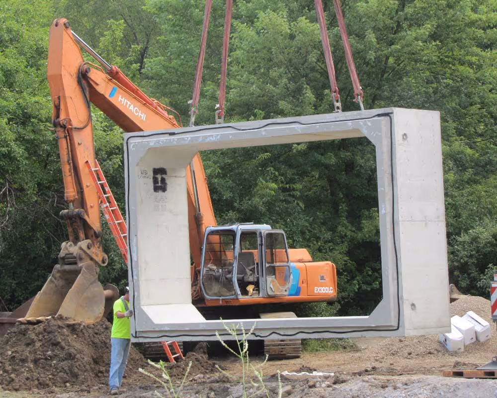 Precast concrete culvert structure being installed by excavation crew during drainage and infrastructure construction project in Ohio.