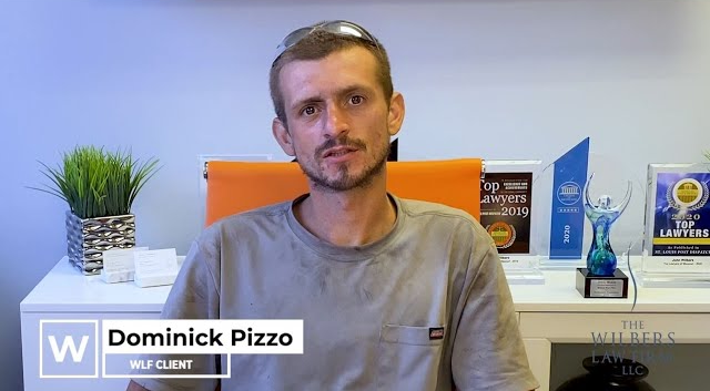 Man identified as Dominick Pizzo sitting in an office with awards and a plant on the shelf behind him.