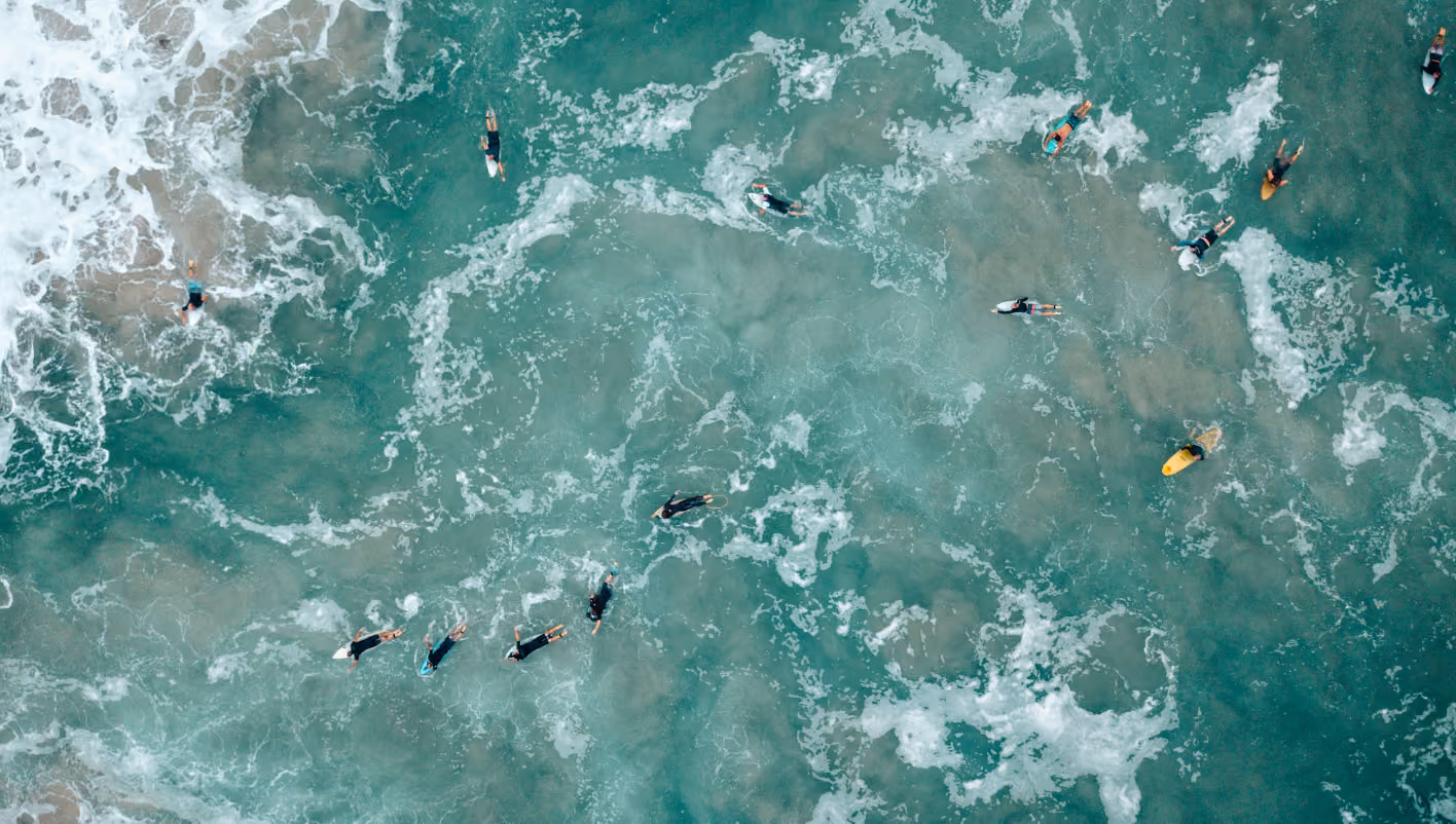 People surfing in the ocean, riding waves on surfboards.