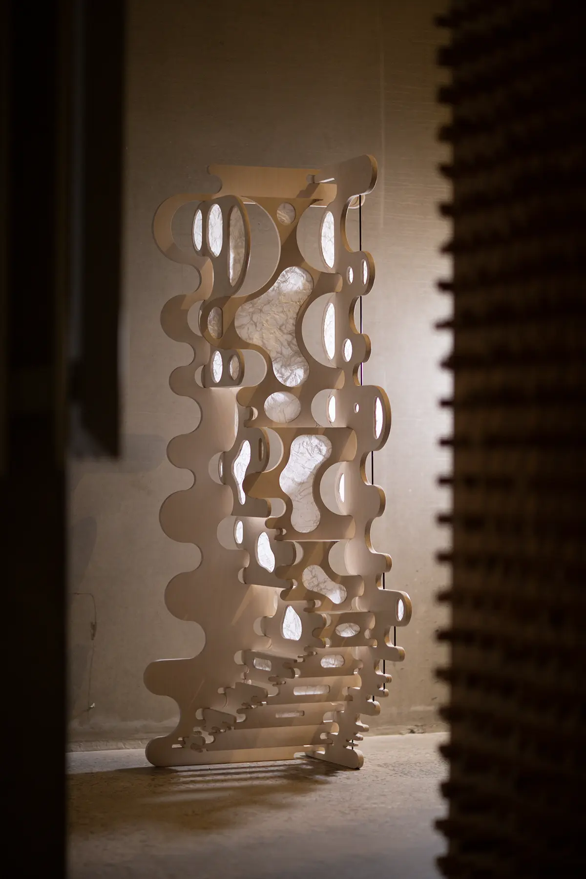 Full view of timber kirigami screen in open configuration within interior space