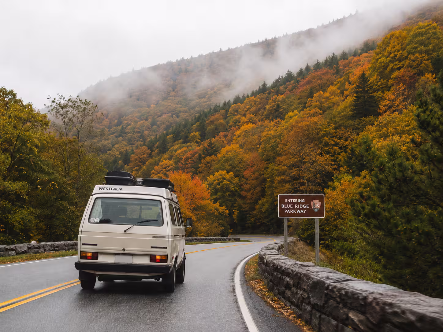 Camper van driving a mountain road toward the Blue Ridge Parkway near Asheville