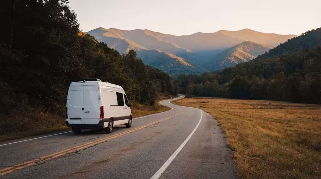 Class B camper van on a two lane road running west into national forest country