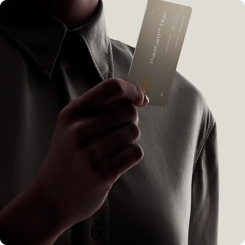 Person holding a beige PointCard™ Tien credit card against a neutral background.