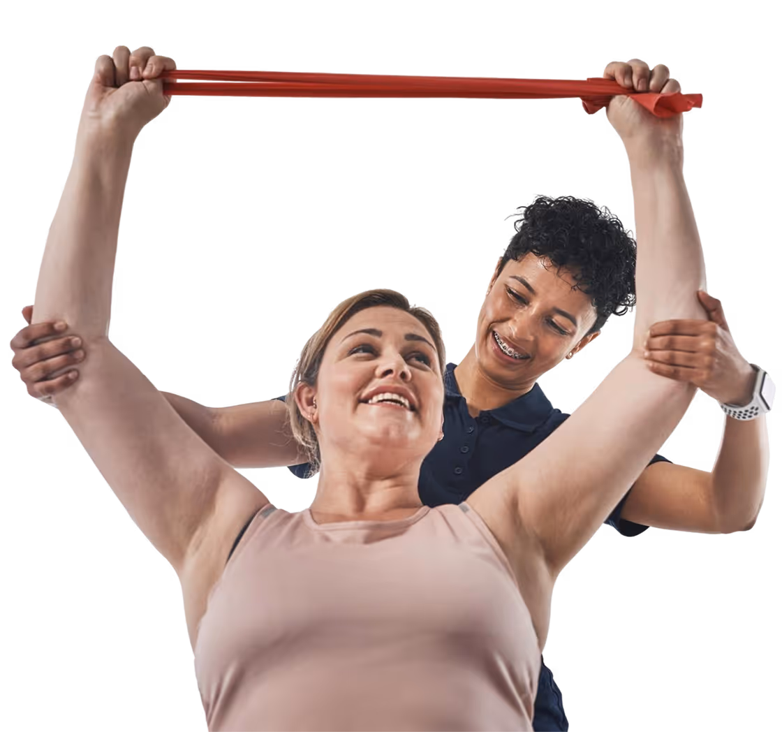 Une femme fait un exercice d'étirement guidé par une autre personne qui l'aide à lever un élastique rouge.