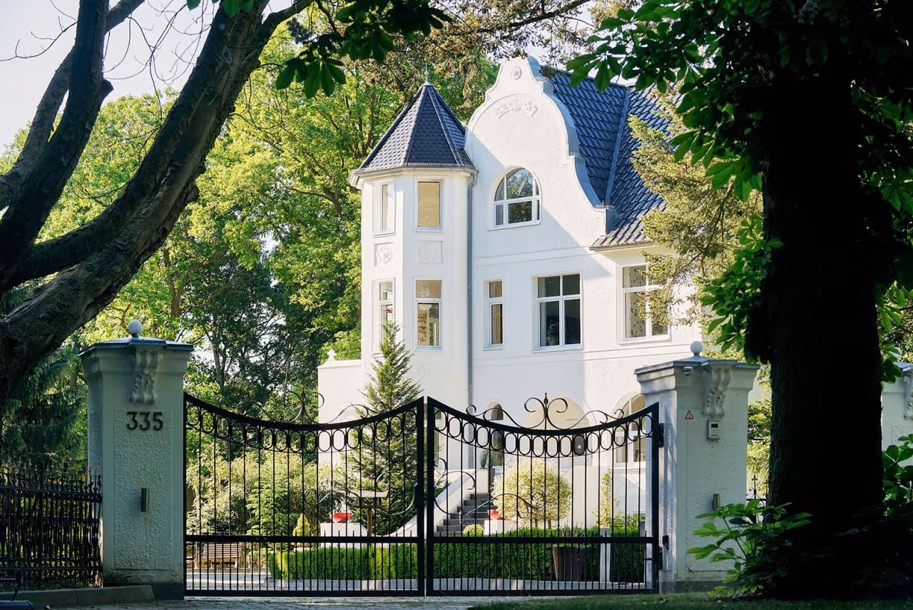 Weiße Villa mit gepflegter Fassade als Beispiel für hochwertige Sanierung und Modernisierung