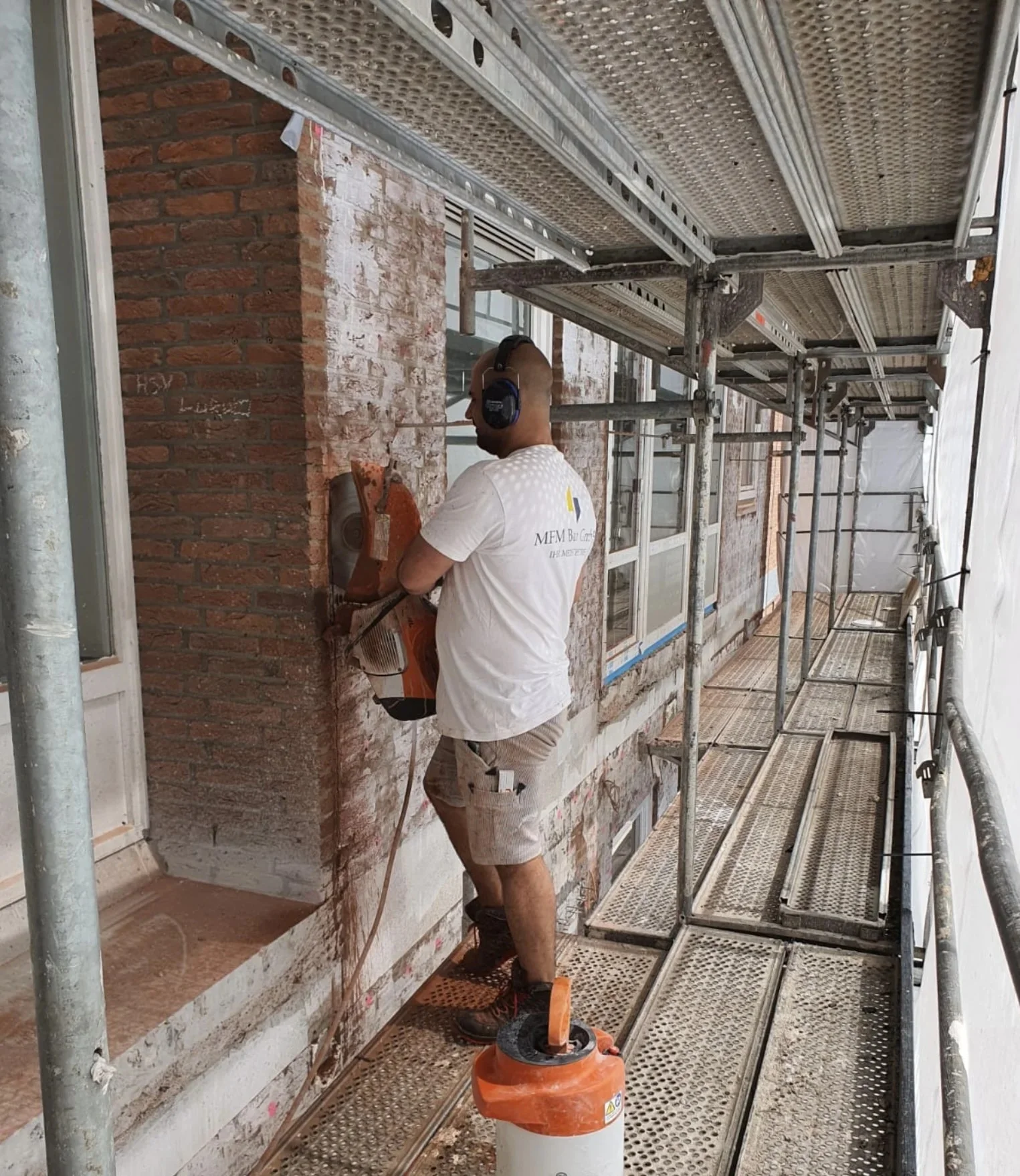 Fassadenarbeiten von MFM Bau GmbH auf dem Gerüst mit präzisem Rückbau an der Außenwand