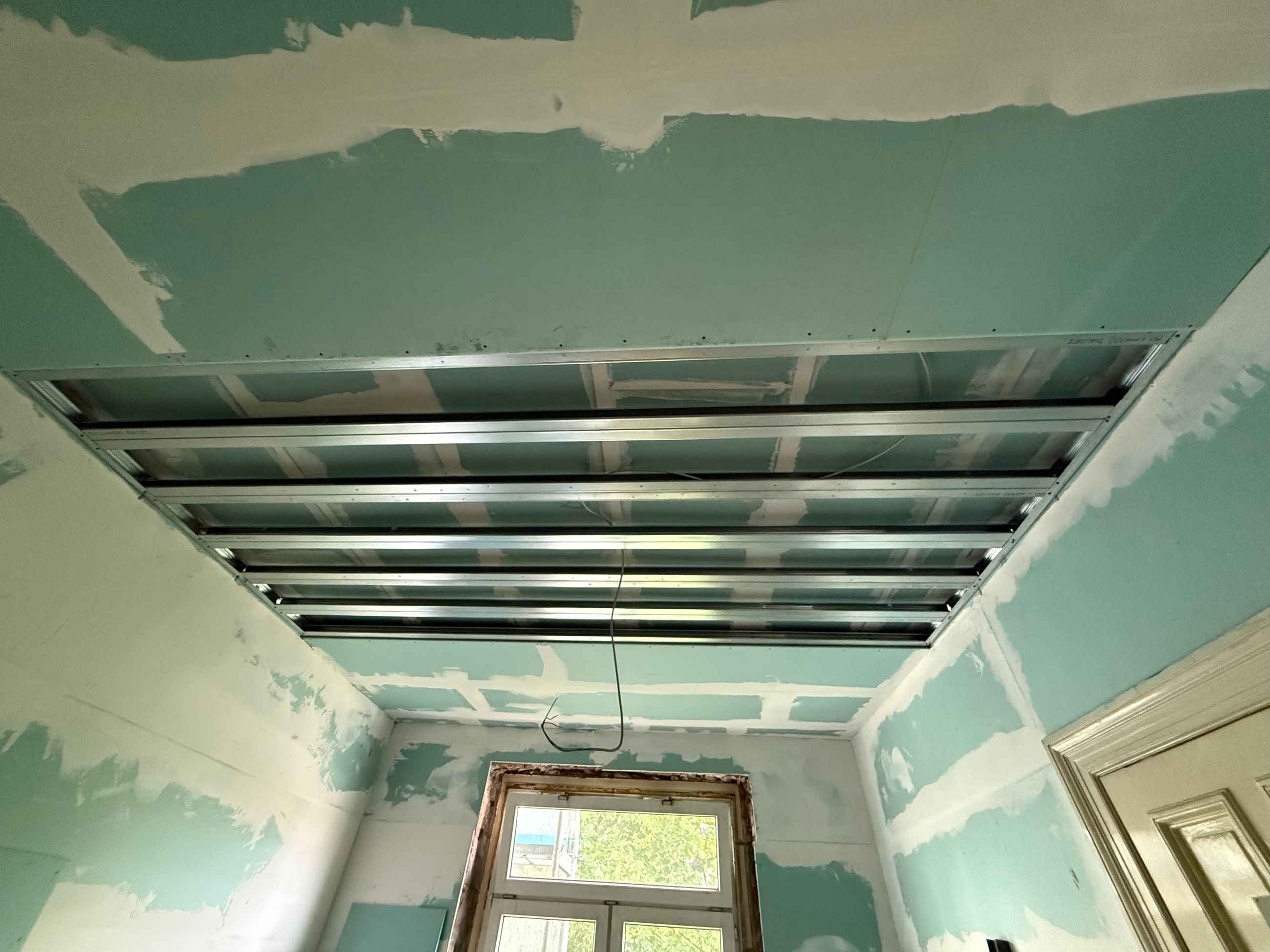 Trockenbau Decke mit Metallprofilen und vorbereiteten Plattenflächen für den Innenausbau