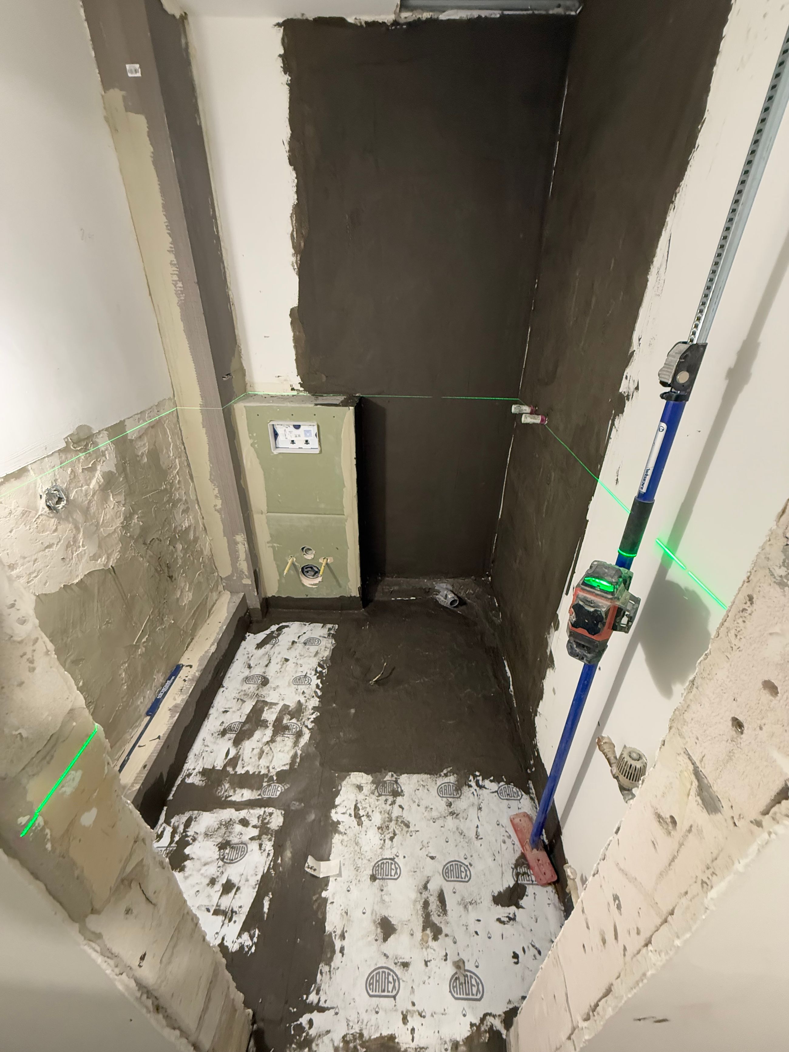 Badezimmer während Rückbau und Badsanierung mit freigelegtem Boden und vorbereiteten Wandflächen