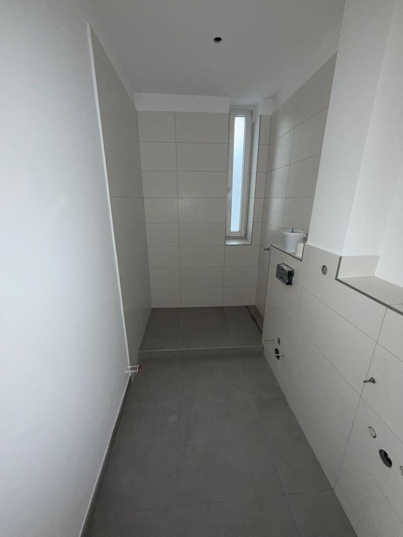 Badezimmer während der Badsanierung mit vorbereiteten Anschlüssen, Estrich und neuen Wandflächen