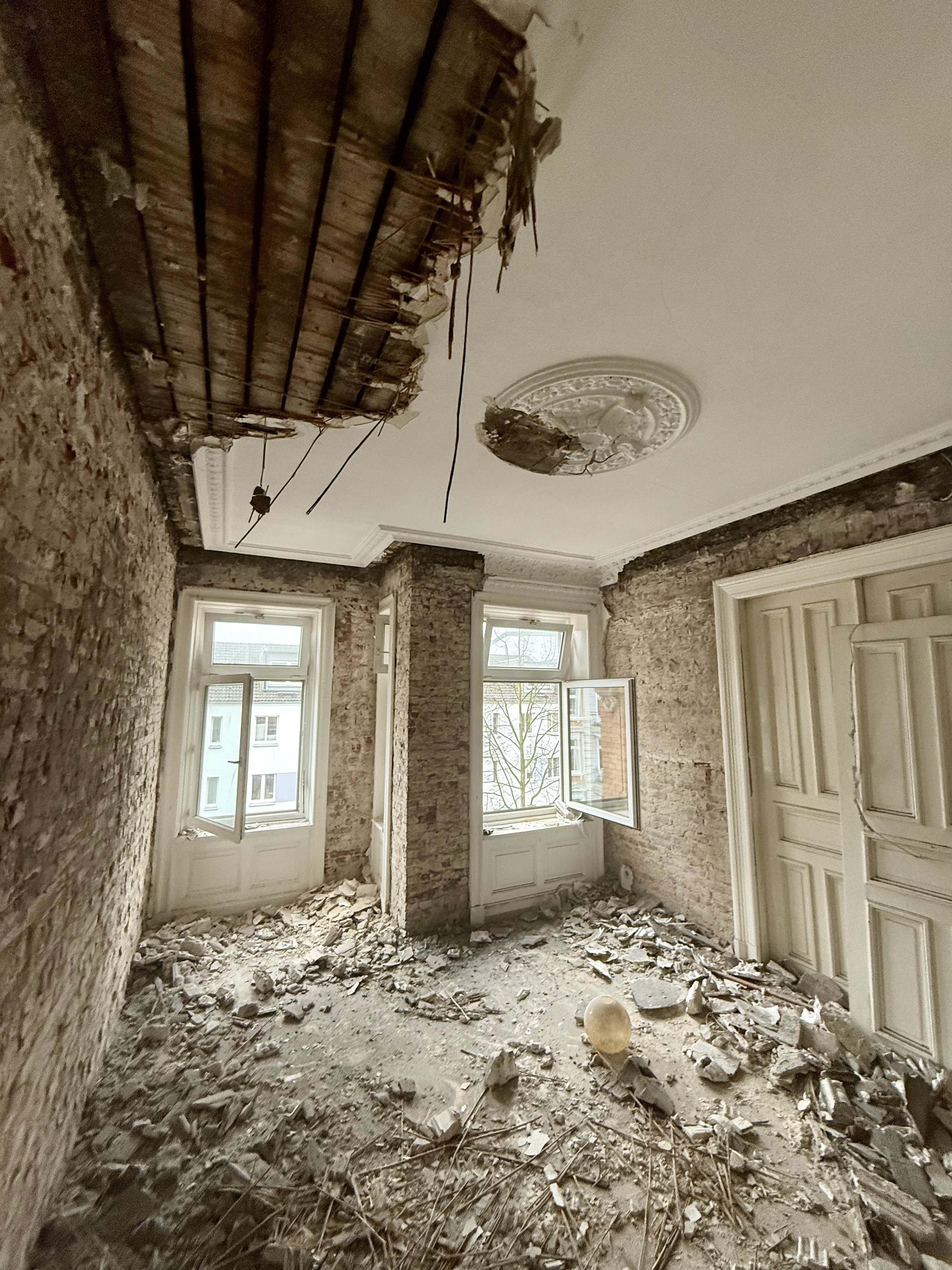 Altbauzimmer während Rückbau und Umbau mit freigelegter Decke, Bauschutt und alten Wandflächen