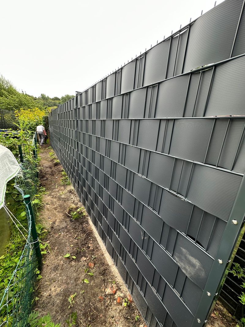 Moderne Zaunanlage entlang des Grundstücks als Teil der Außenanlagen Modernisierung