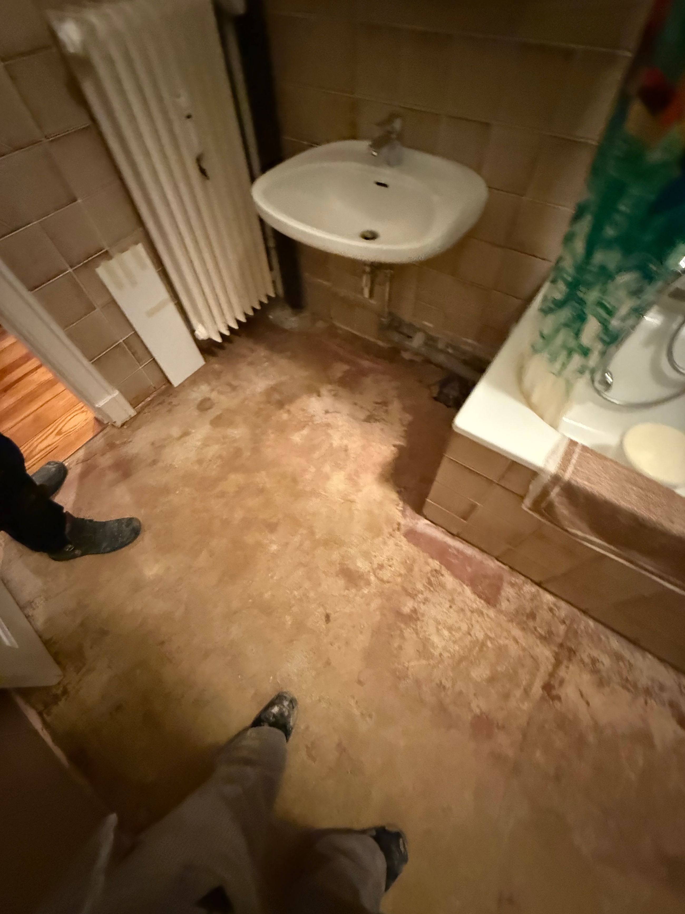 Badezimmer während der Wasserschaden Sanierung mit geöffnetem Boden und vorbereiteten Flächen