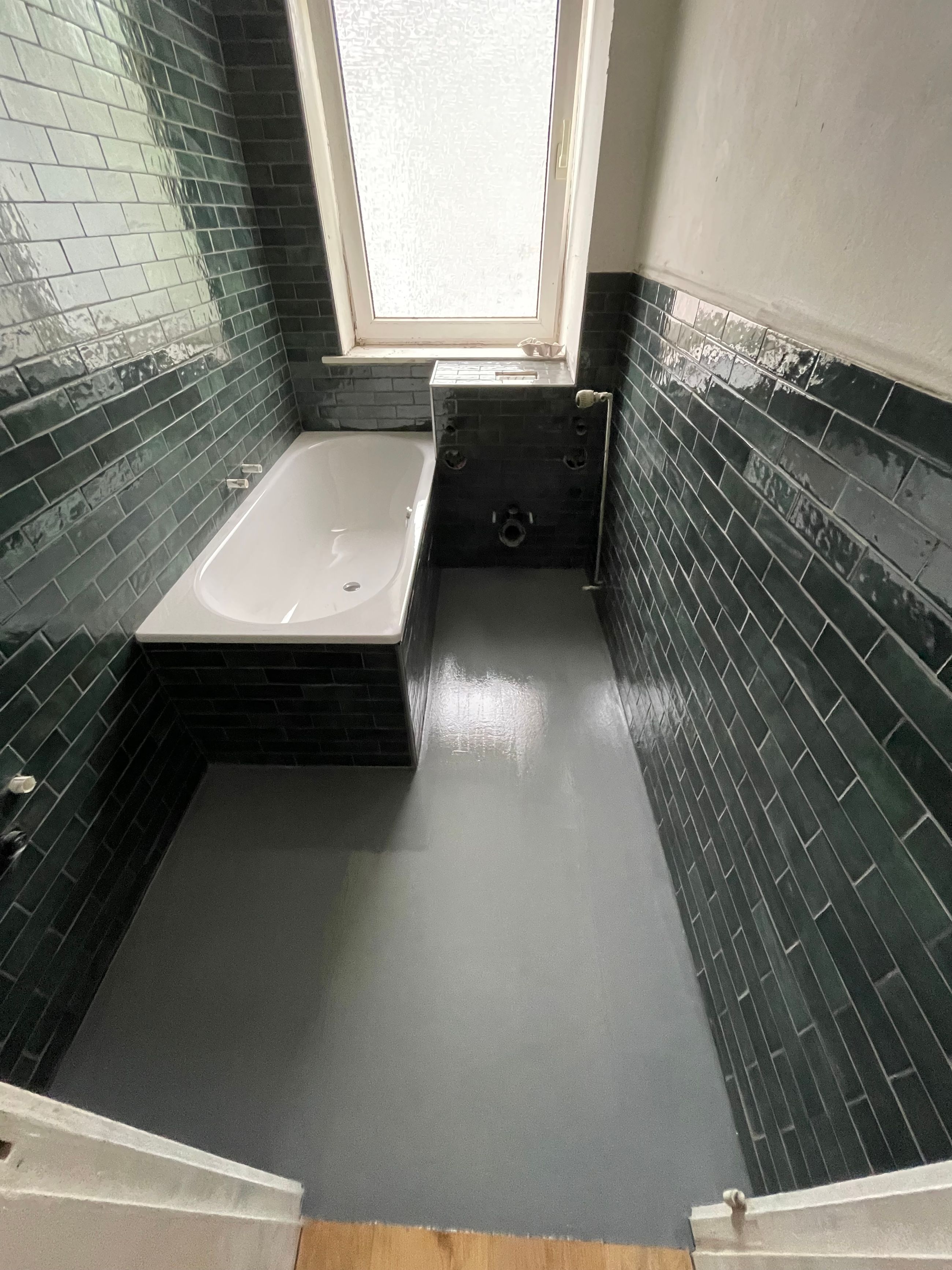 Badezimmer mit Badewanne und grünen Fliesen im Bestand vor der geplanten Badsanierung