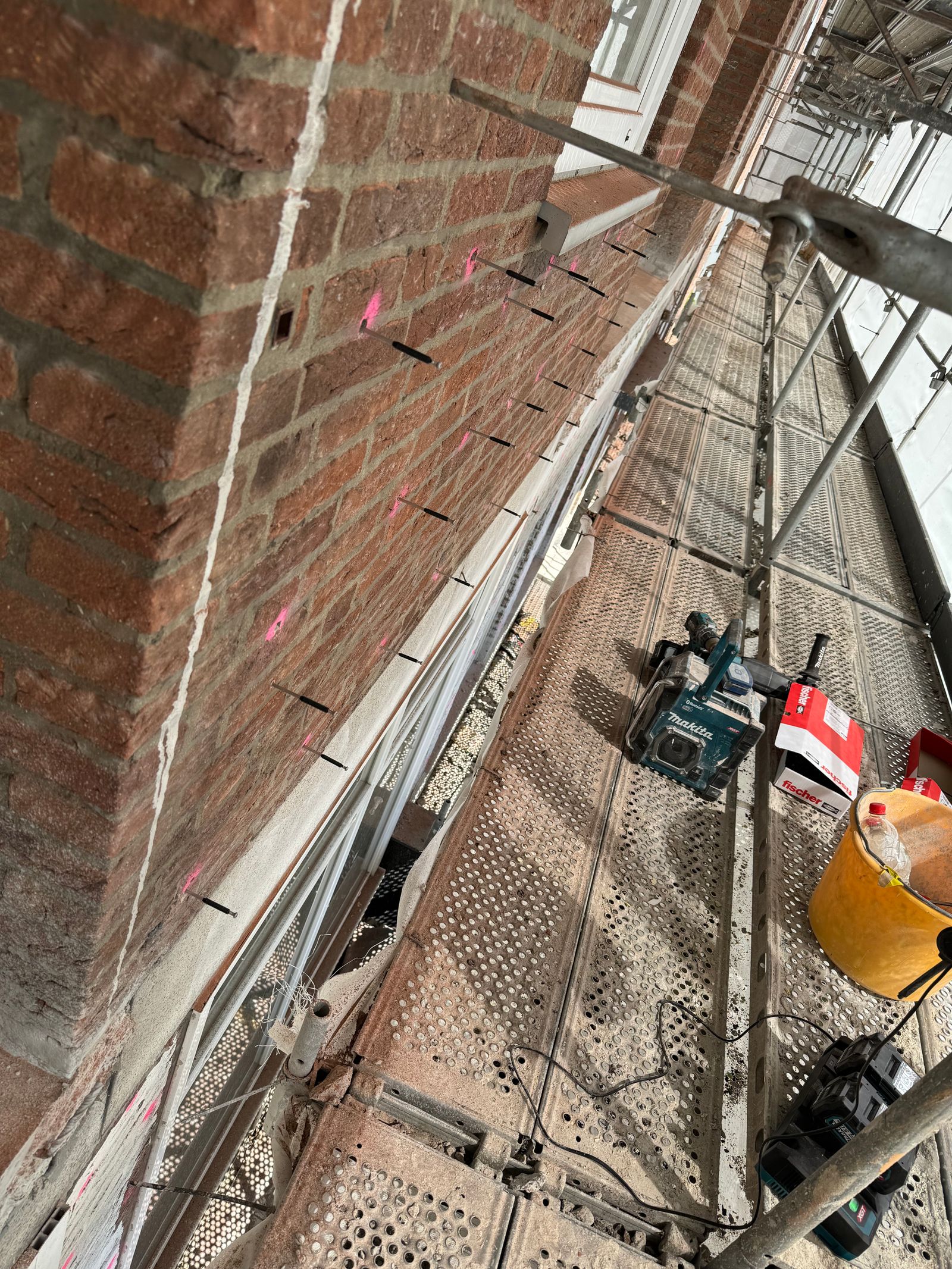 Fassadensanierung an einer Außenwand mit vorbereiteten Flächen für Reparatur, Schutz und Modernisierung