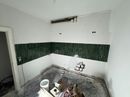 Badezimmer während der Fliesenarbeiten mit grüner Fliesenbordüre
