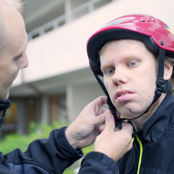 Assistent hjälper till med hjälm