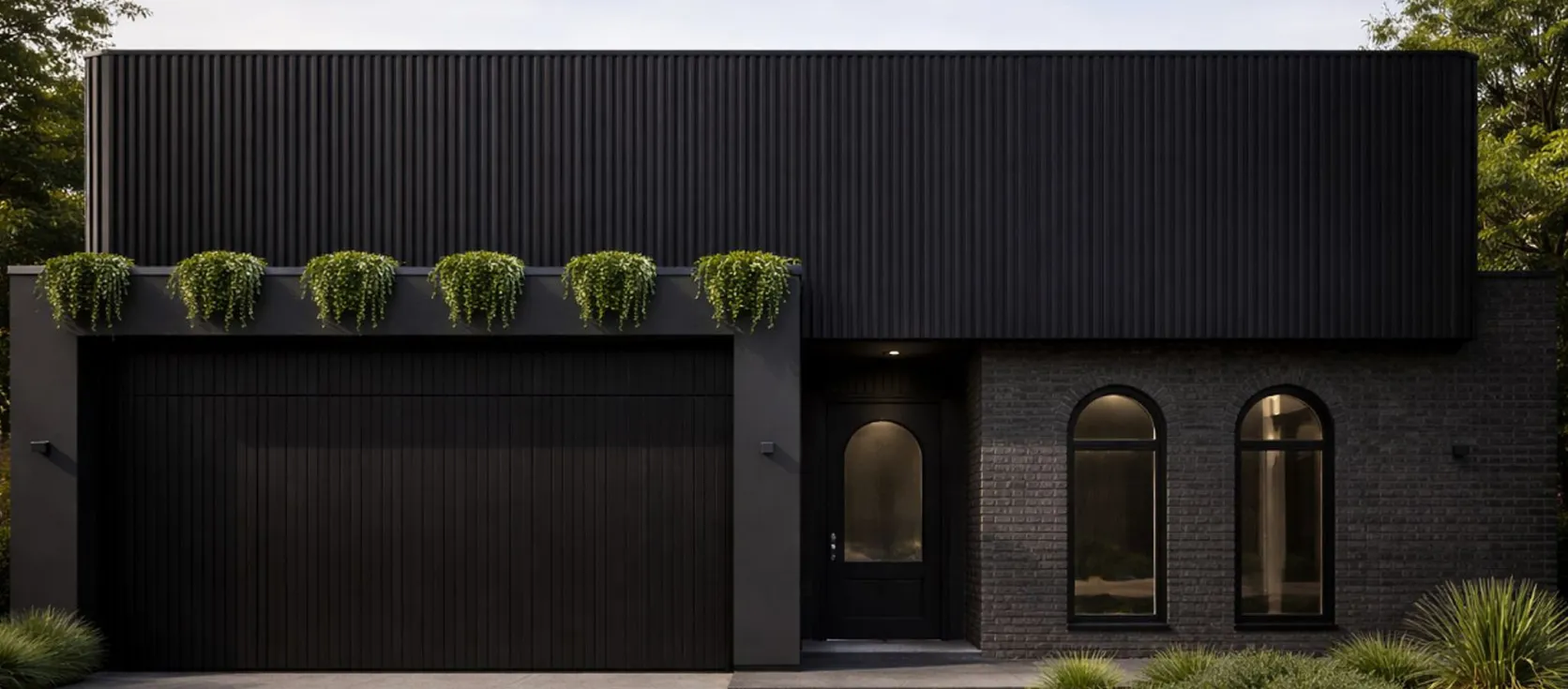 Modern black house exterior with vertical paneling, a garage door, arched windows, entrance door, and green plants above garage.