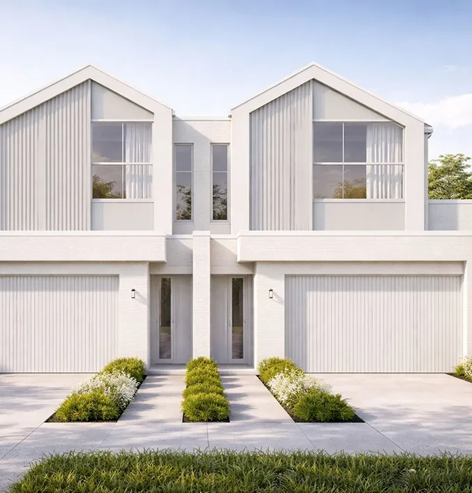 Modern twin white houses with gabled roofs, large windows, and attached garages, separated by a shared pathway with green shrubs.