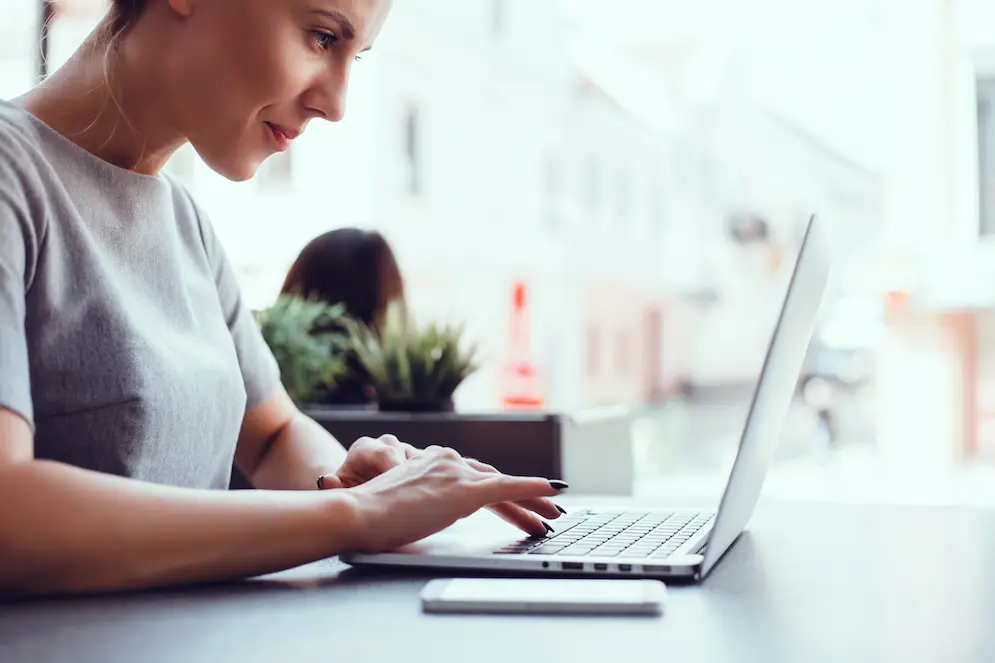 Femme utilisant un ordinateur portable dans un café