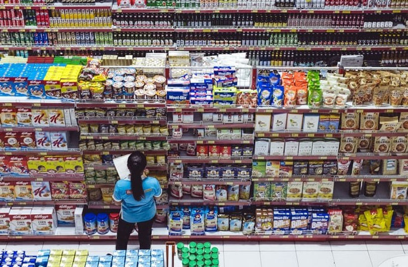 A photo of a supermarket assistant at work in a grocery store. 