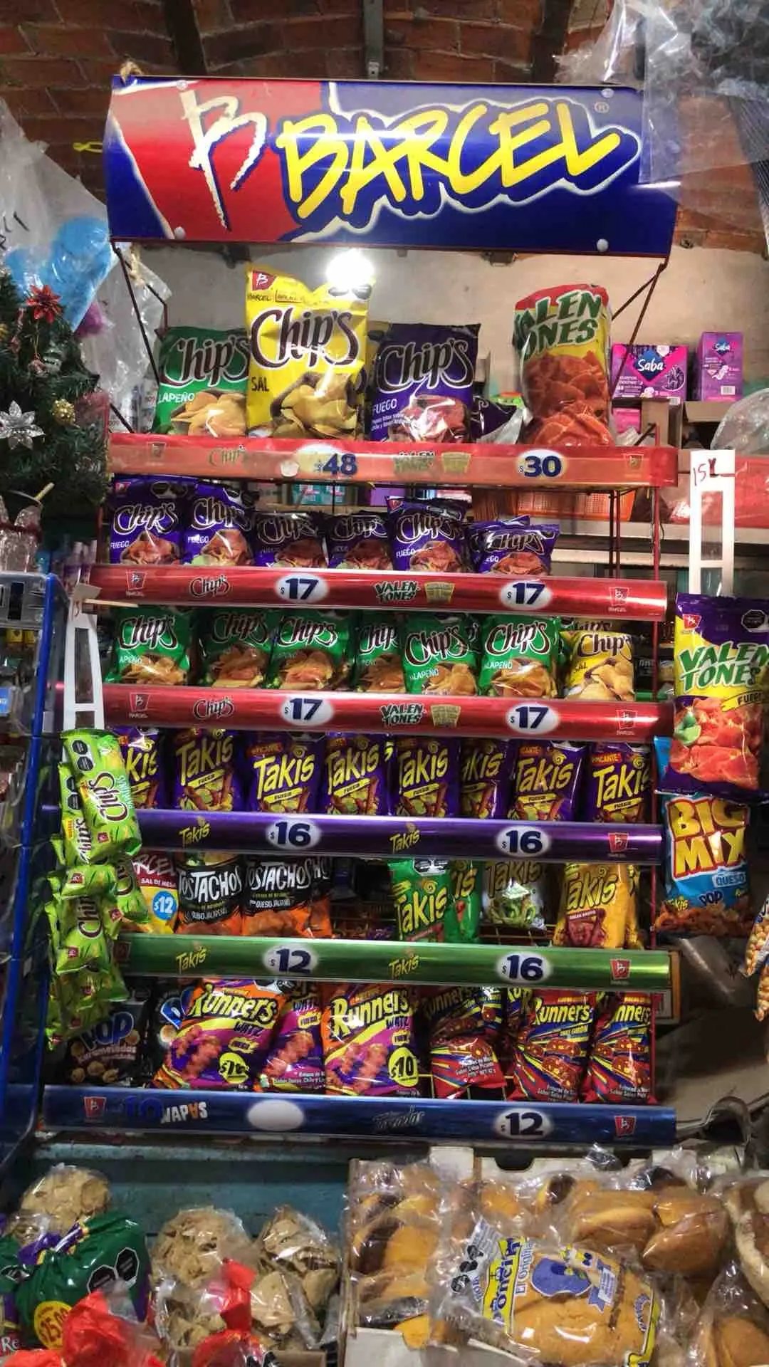 Chaotic traditional store display packed with crisps and snacks across multiple brands and price points.