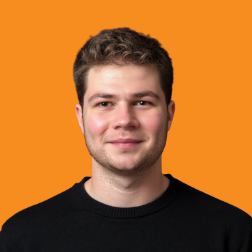 Headshot of a Neurolabs team member in a black jumper against an orange background
