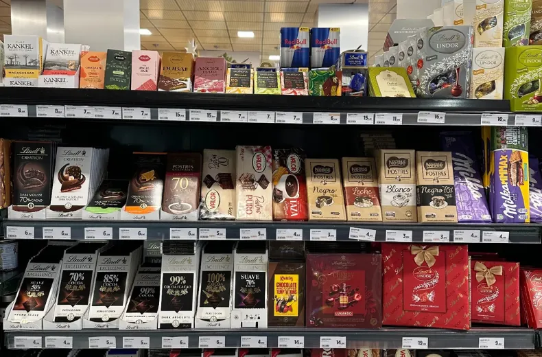 Chocolate fixture with Lindt Excellence and Lindor, Nestle Postres, Valor and Milka lines and full shelf-edge pricing