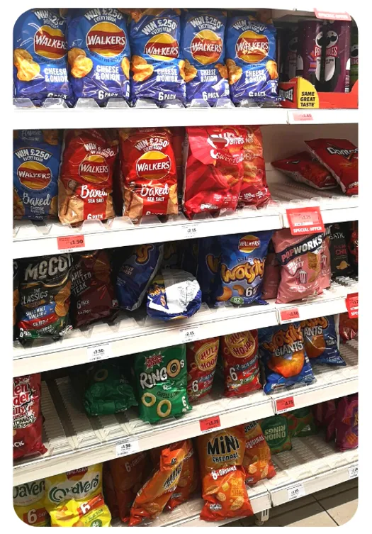 Crisps and snacks aisle in a UK supermarket, fully faced across six shelves with price labels on every facing