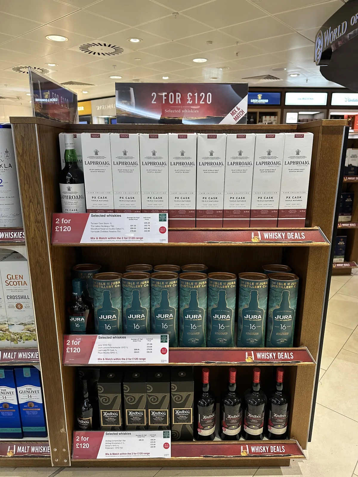 Whisky shelf with Laphroaig PX Cask, Jura 16 and other single malts beneath 2 for £120 mix and match whisky deal signage