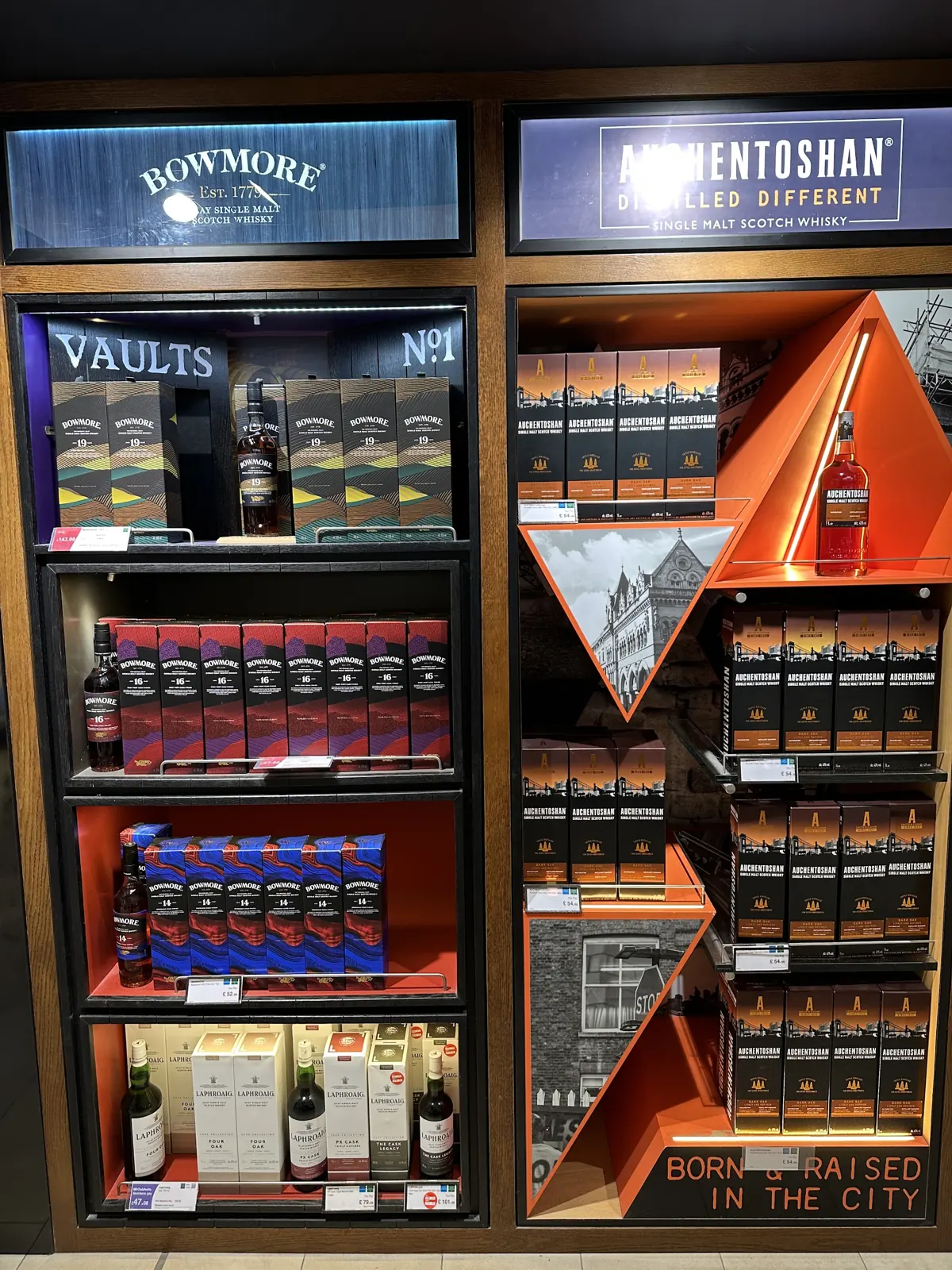 Branded Bowmore and Auchentoshan display bays stocked with single malt Scotch whisky bottles and gift boxes