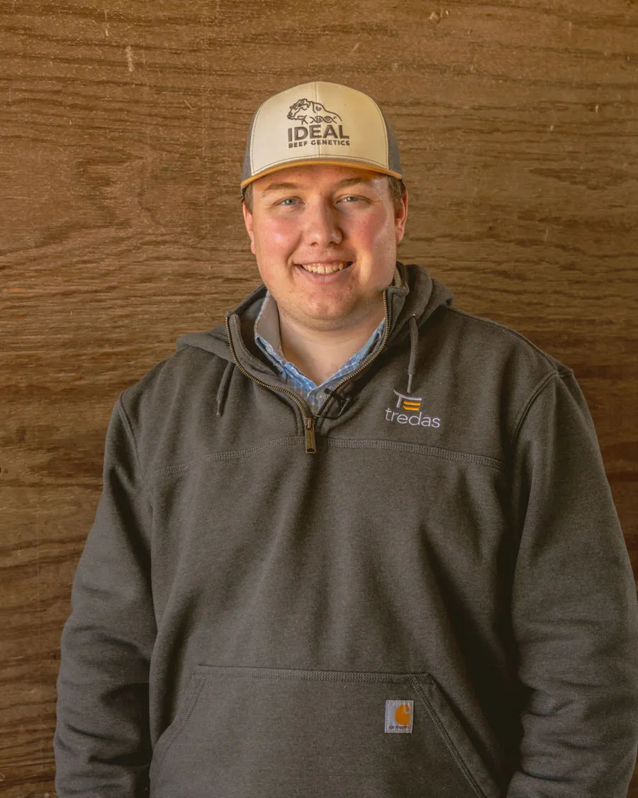 rancher wearing grey sweatshirt and hat smiling