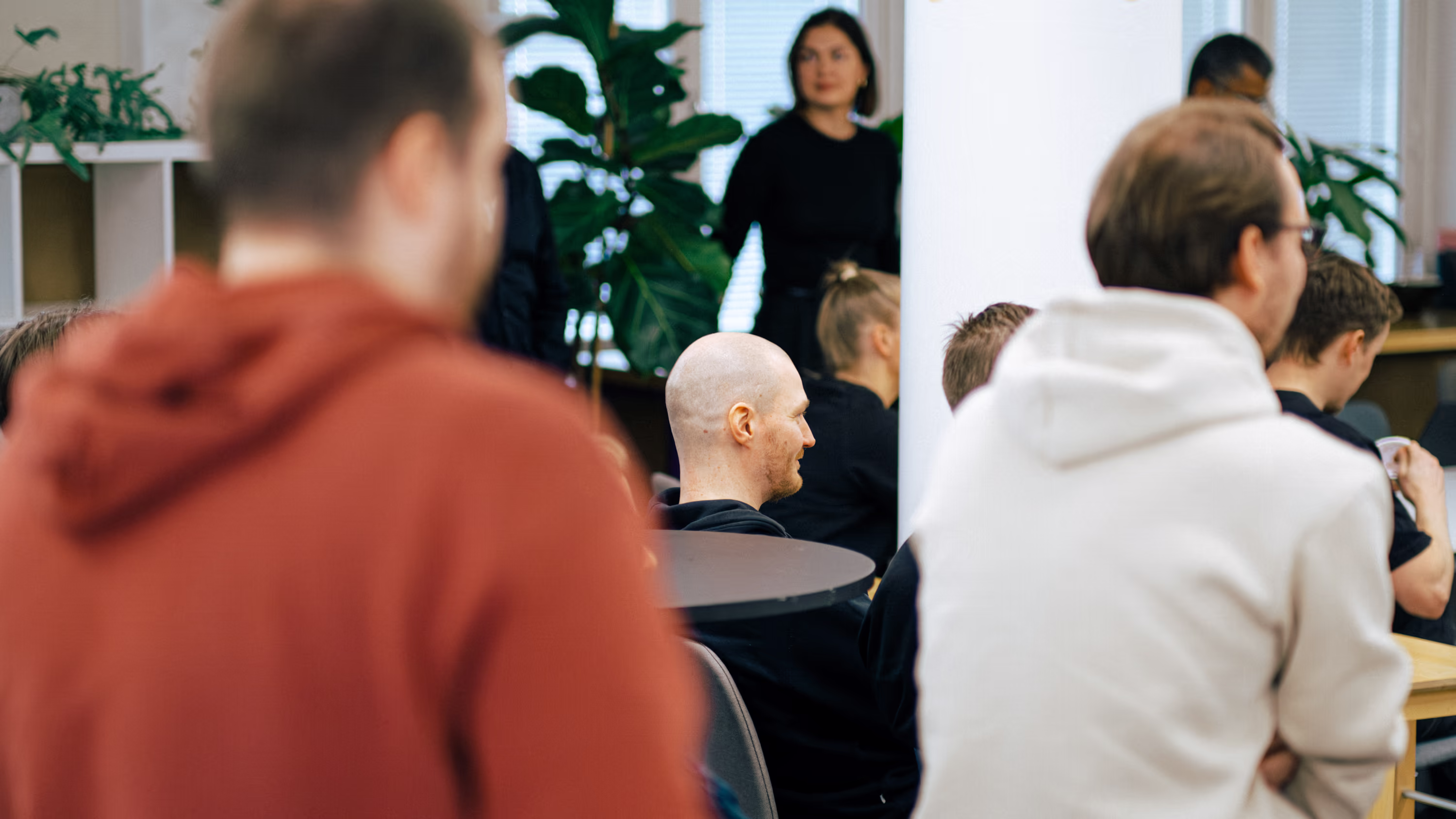 People sitting and attentively listening in a casual indoor group meeting.