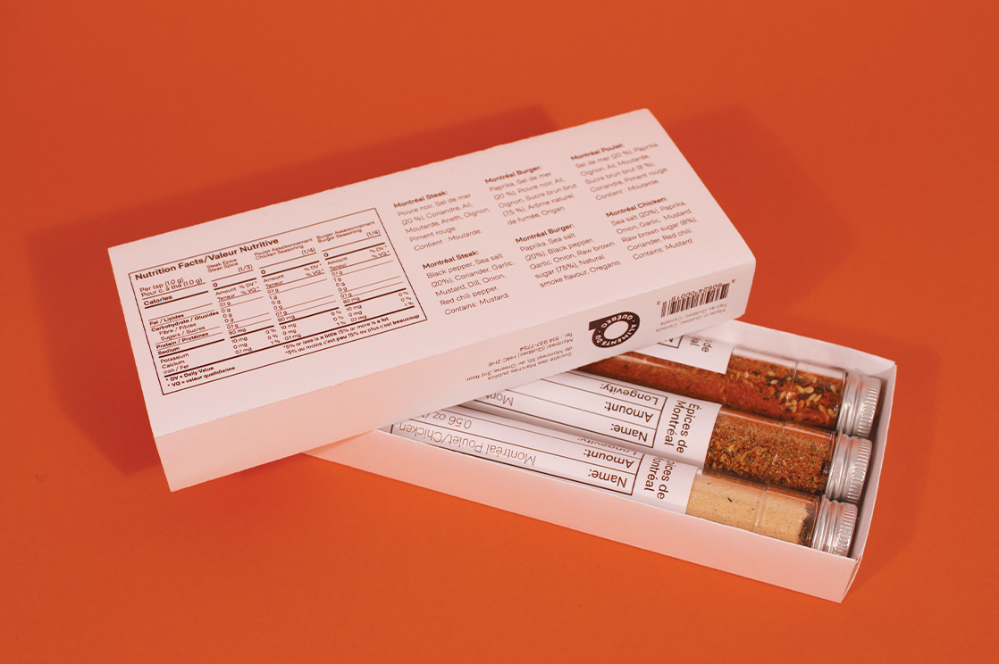 An overhead shot of the packaging showcasing the three spices inside and the back with the nutritional information against an orange background.