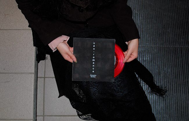 An image of someone holding the vinyl adaptation while also pulling the vinyl out of the sleeve.