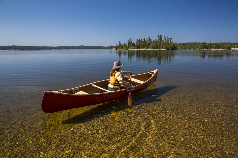 Solo canoe on crystal-clear water