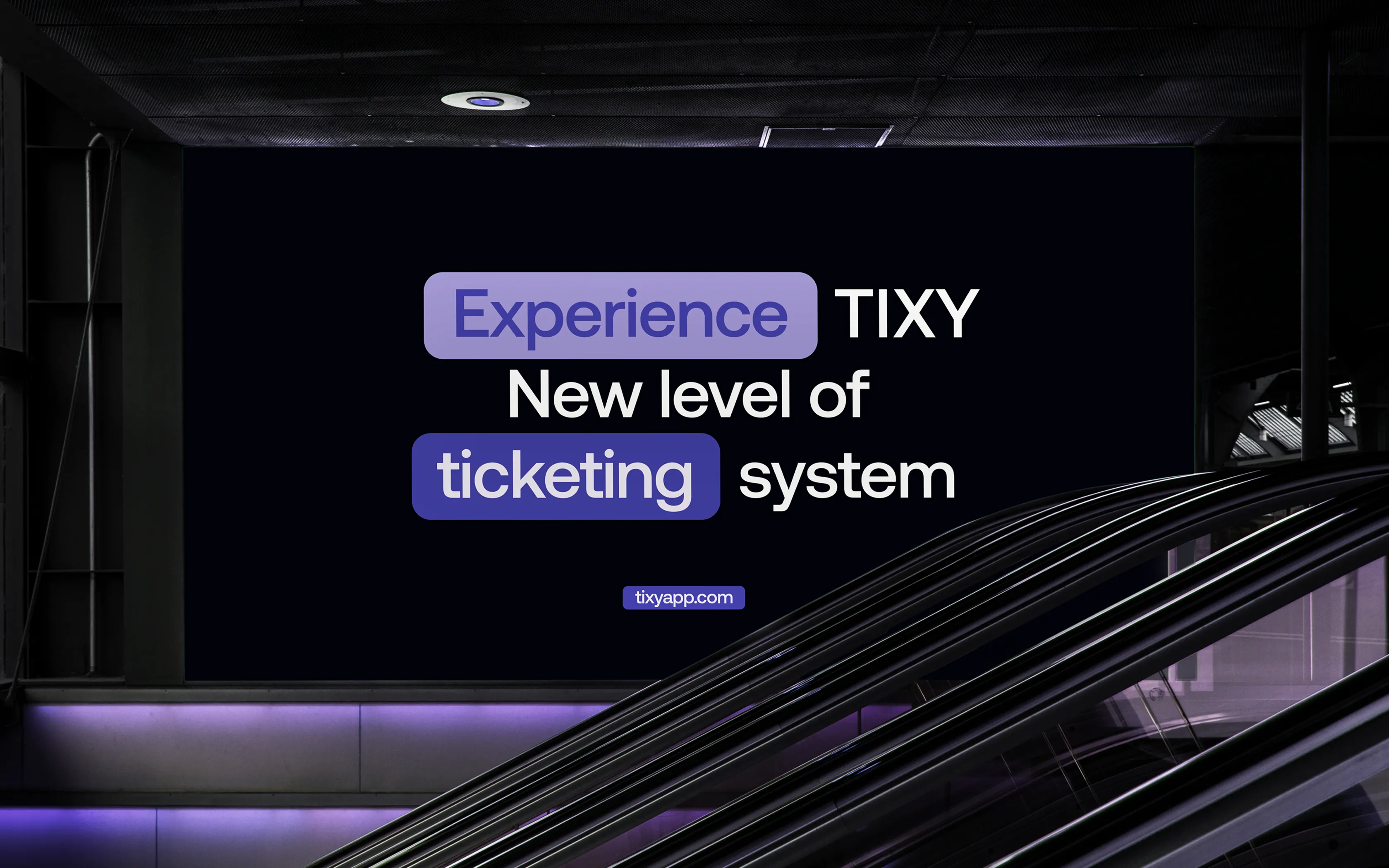 Backlit advertisement in a dark interior with escalators, showing text: 'Experience TIXY New level of ticketing system' and website tixyapp.com.
