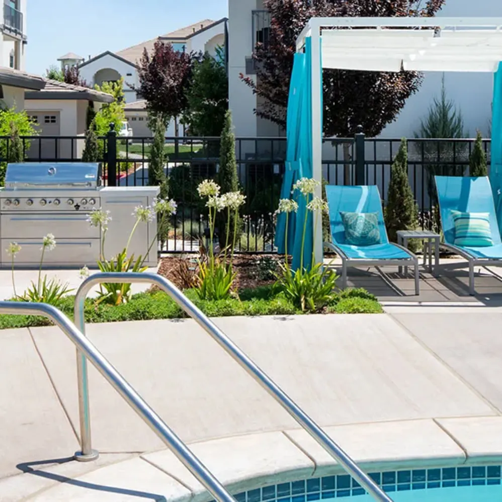Pool entrance with lounge seating and BBQ area
