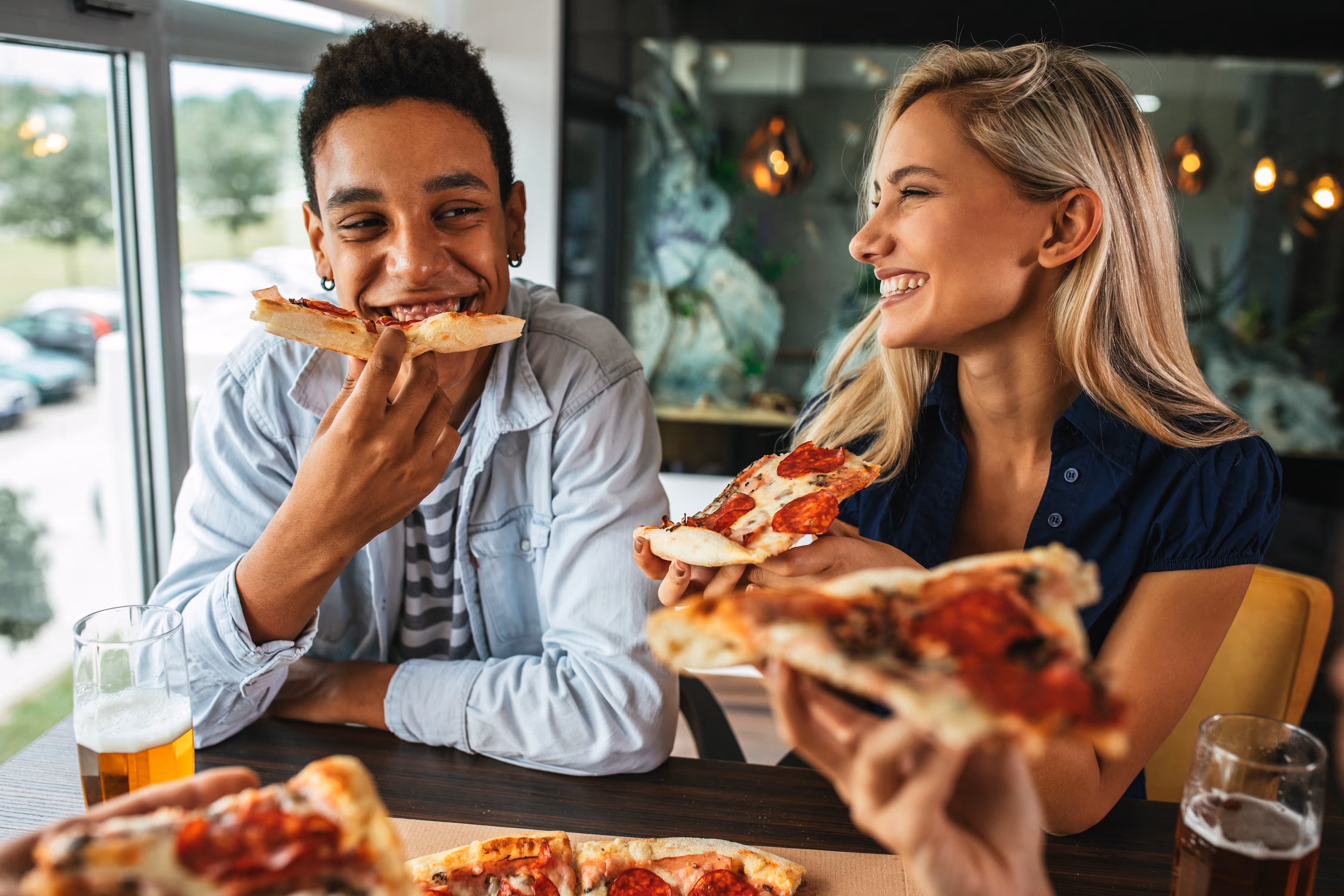 Two people eating pizza at a restaurant stock image