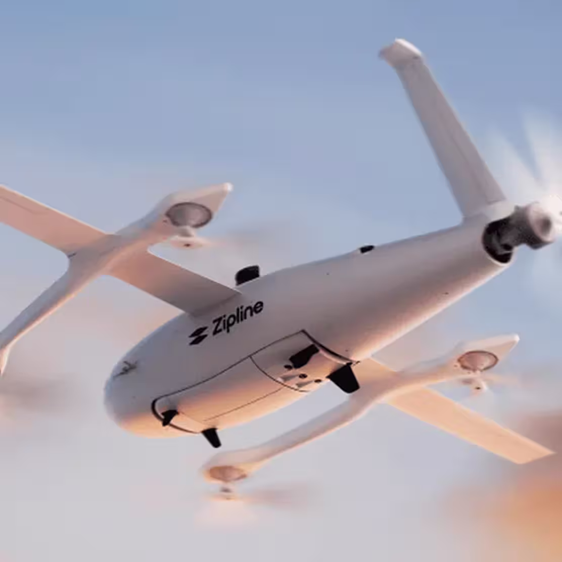 White Zipline drone with four propellers flying against a blue sky at sunset.