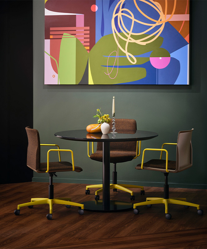 Disc base table with colorful chairs. 