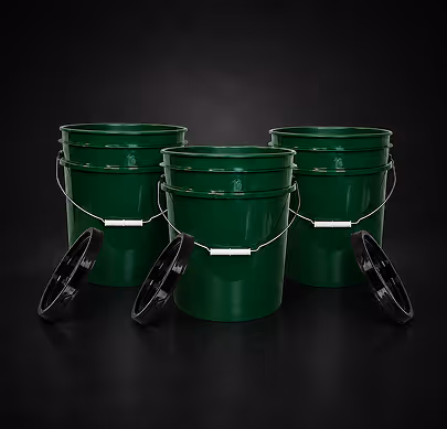 Three green plastic buckets with black lids, arranged against a black background.
