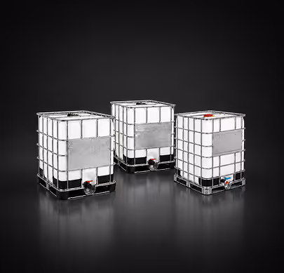 Three large white industrial liquid storage containers with metal frames on a black background.