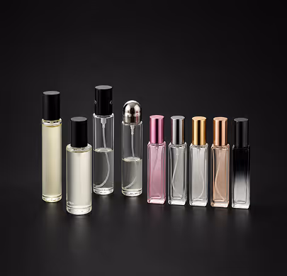 Eight different perfume bottles with black, silver, pink, gold, rose gold caps on a black background.