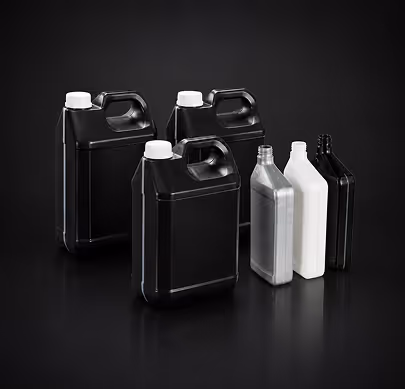 Three black and three white plastic containers of various shapes on a reflective black surface.