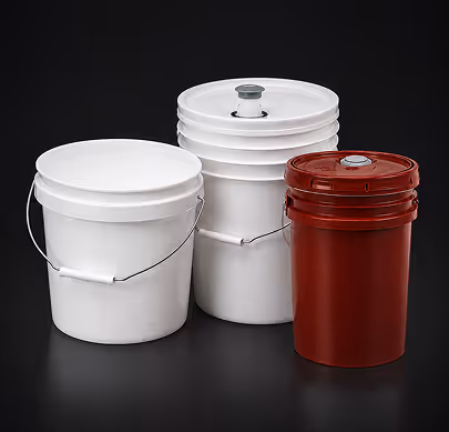 Two white plastic buckets with handles and one red plastic bucket with a screw-on lid on a black background.