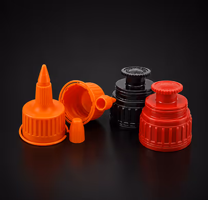 Four plastic bottle caps in orange, black, and red on a black surface.